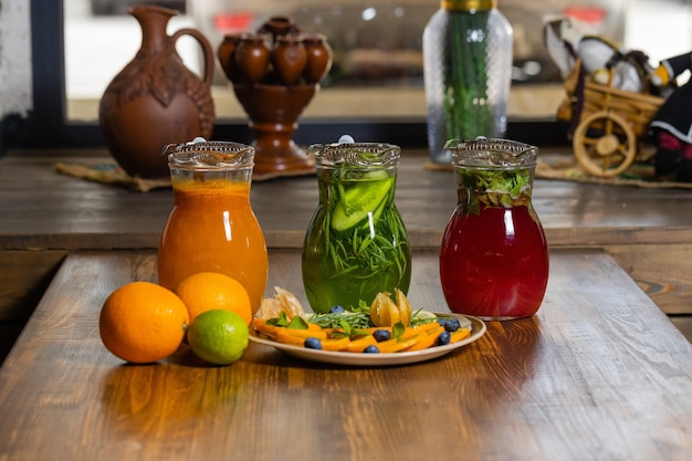 Limonadas de frutas y bayas en la bandeja de madera con abeto