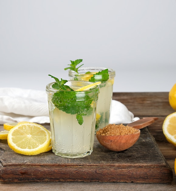 Limonade des Sommerauffrischungsgetränks mit Zitronen, tadellose Blätter in einem Glas