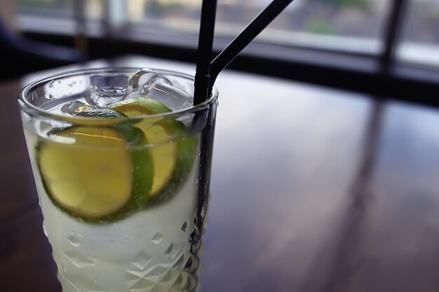 Limonade im Glascafé / frische Limonade mit Eis und Limette in einem Glas auf Restauranthintergrund