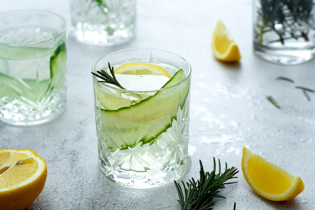 Limonade mit frischen Gurken, Zitronen und Rosmarin in einem Glas auf hellem Hintergrund