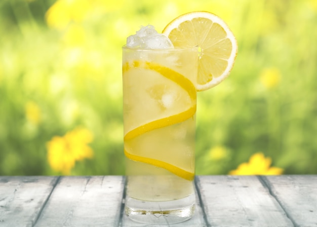 Limonade mit frischer Zitrone im Hintergrund