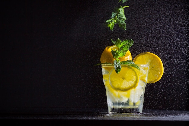 Limonade mit Minze und Zitrone Sommer erfrischendes Getränk mit Zitrone auf dunklem Hintergrund