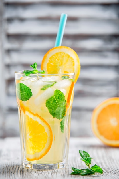 Limonade mit Orange und Eis auf weißem Schiebefensterhintergrund