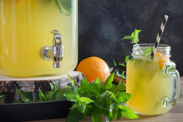 Limonade mit Orangenzitrone und Minzcocktail im Einmachglas mit Minze auf schwarzem Steintisch Platz für Text kopieren