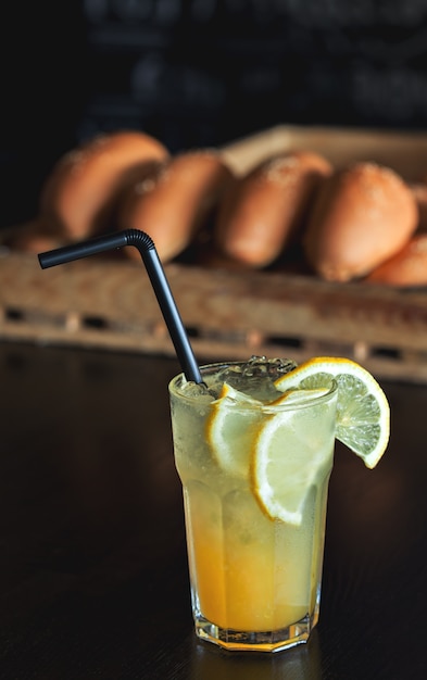 Foto limonade mit zitrone und sirup auf frisch gebackenen brötchen im cafe. sommergetränk