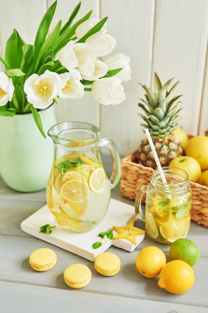 Limonade, süße Macarons, Früchte und Tulpenblüten