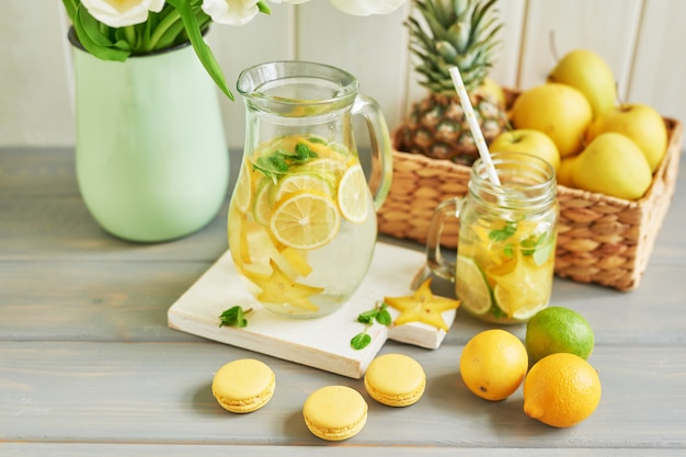 Limonade, süße Macarons, Früchte und Tulpenblüten