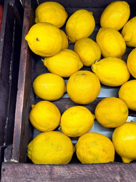 Foto los limones amarillos brillantes se encuentran en una caja de madera uno al lado del otro.