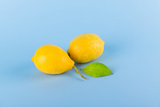 limones amarillos frescos sobre un fondo azul pastel