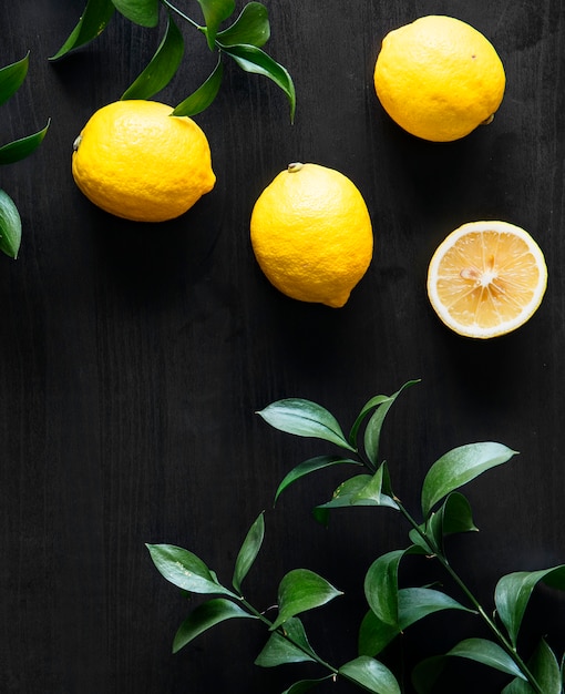 Limones amarillos frescos sobre fondo negro