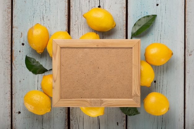 Limones amarillos y hojas con caja vacía