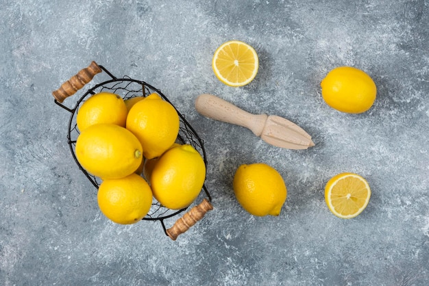 Limones en caja de tazón de madera sobre fondo gris