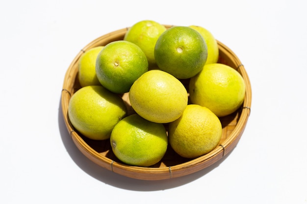 Limones en canasta de bambú en blanco