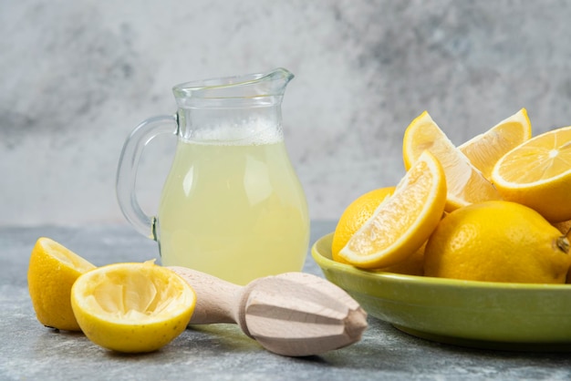 Limones fondo gris jugo de limón y fresco en la tabla de cortar