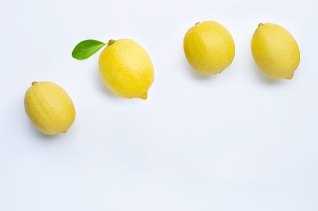 Limones frescos con hoja verde sobre fondo blanco.