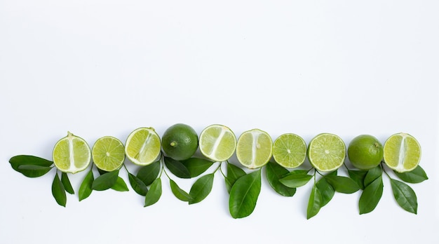 Limones frescos con hojas verdes sobre fondo blanco. Vista superior