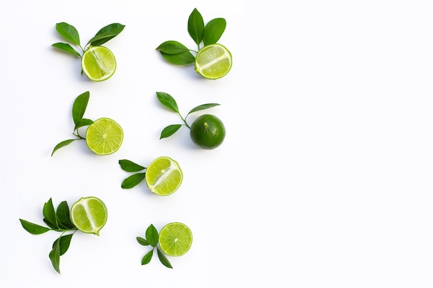 Limones frescos con hojas verdes sobre fondo blanco. Vista superior