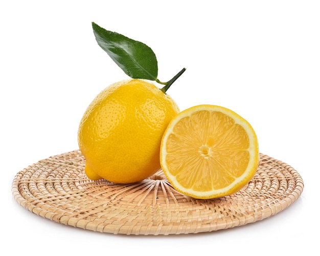 Foto limones con hoja verde en tejido de bambú aislado sobre fondo blanco.