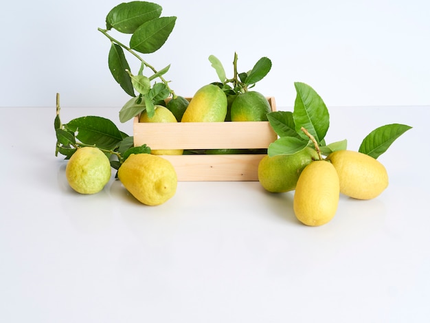 Limones con hojas en caja de madera.