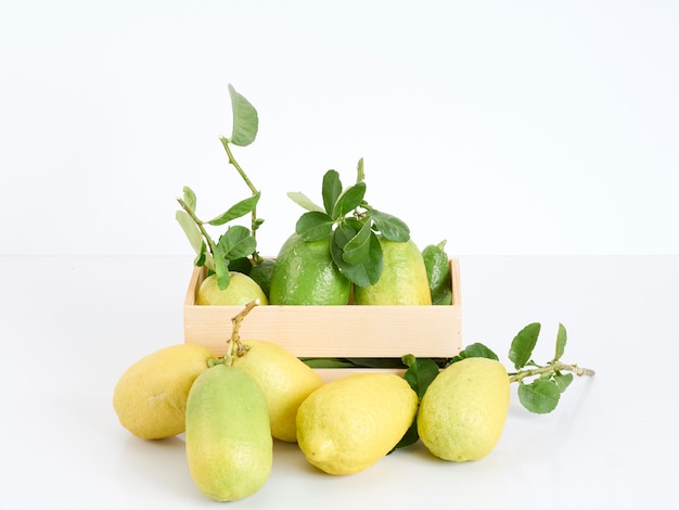 Limones con hojas en caja de madera.