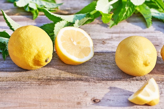 Limones con hojas de menta sobre mesa de madera