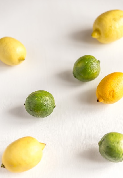 Limones y limas en la mesa blanca