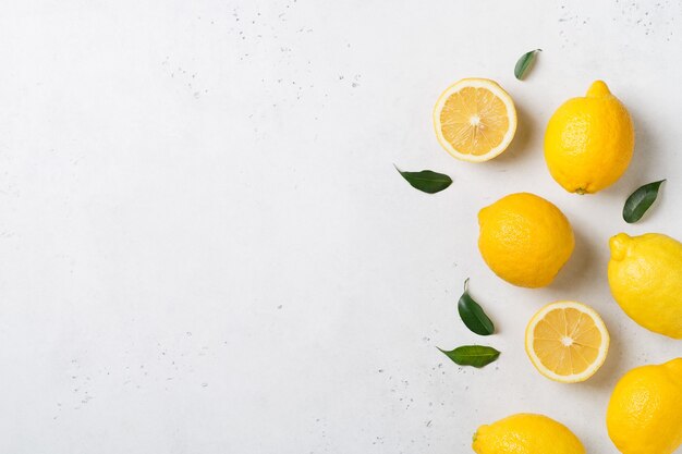 Los limones maduros se ponen planos con hojas en blanco. vista superior