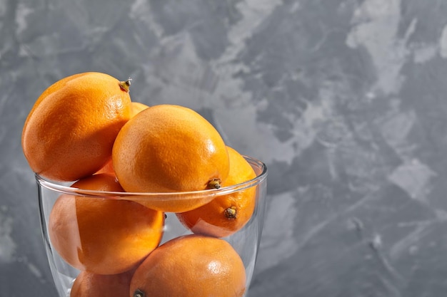 Limones naranjas frescos de Tashkent o limones Meyer en fondo de hormigón Vitamina C