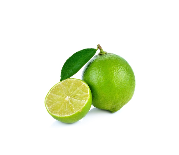 Limones con rodajas y hojas aisladas sobre pared blanca