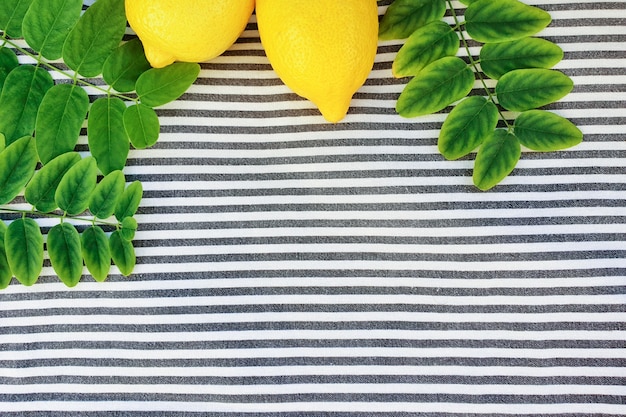 Limones y verduras sobre un tejido a rayas.