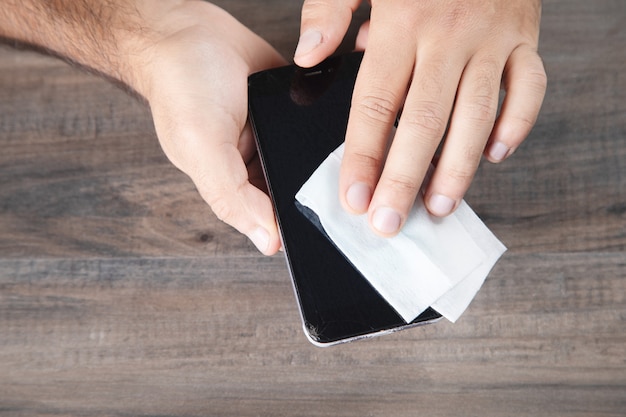 Limpa o telefone com um guardanapo