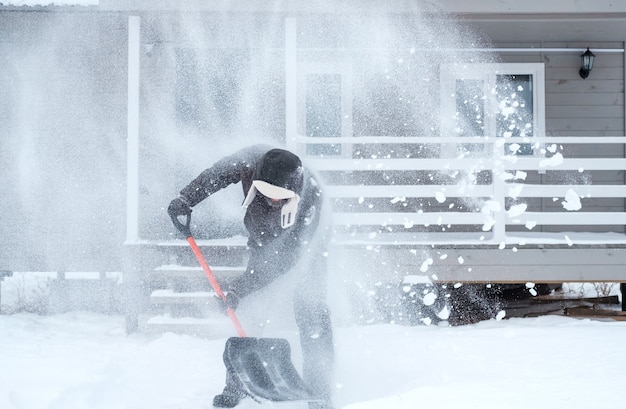 Limpando a neve perto da casa após uma forte nevasca