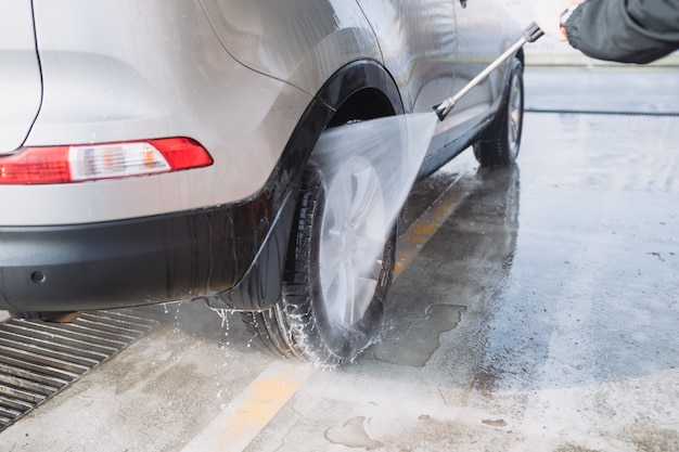 Limpando o carro usando água de alta pressão