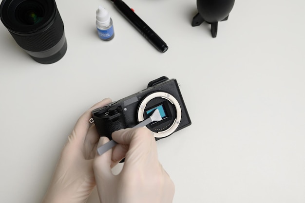 Foto limpando o cotonete de limpeza do sensor da câmera para limpar a sujeira do sensor cuidados com o equipamento fotográfico
