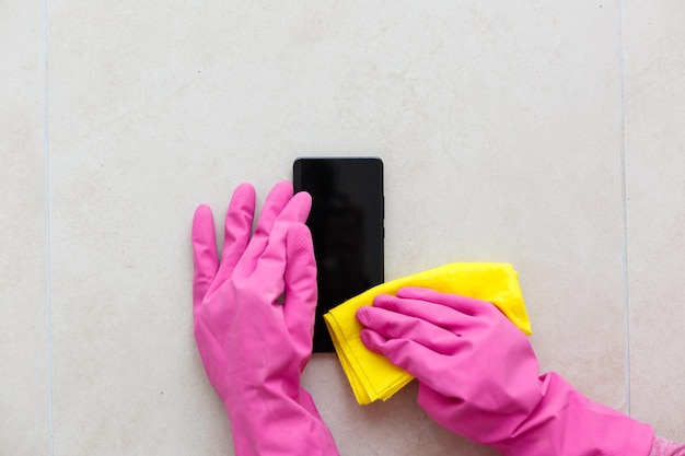 Limpar a tela do smartphone com um pano de fibra de poeira suja e outros fatores externos. Conceito de atendimento móvel
