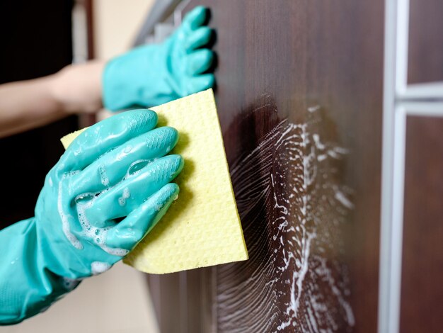 Foto limpar móveis com pano amarelo e detergente