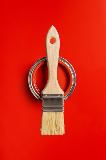 Limpe o pincel e a lata de cor sobre fundo vermelho