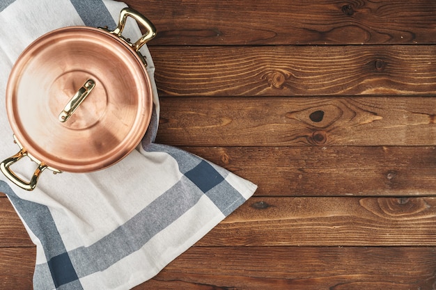 Limpe utensílios de cozinha de cobre brilhante na placa de madeira