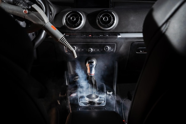 Limpeza a vapor da caixa de velocidades e do painel do carro Vapor de vapor Limpeza de elementos individuais do interior de couro preto no automóvel Anúncio criativo para serviço de detalhamento automático