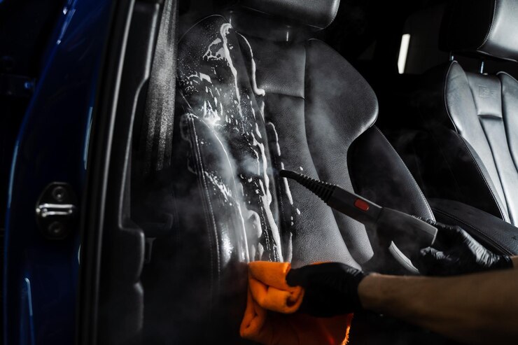 Foto limpeza a vapor do assento de couro após lavagem com espuma e detergente trabalhador no serviço de limpeza automática carro limpo dentro do interior do carro