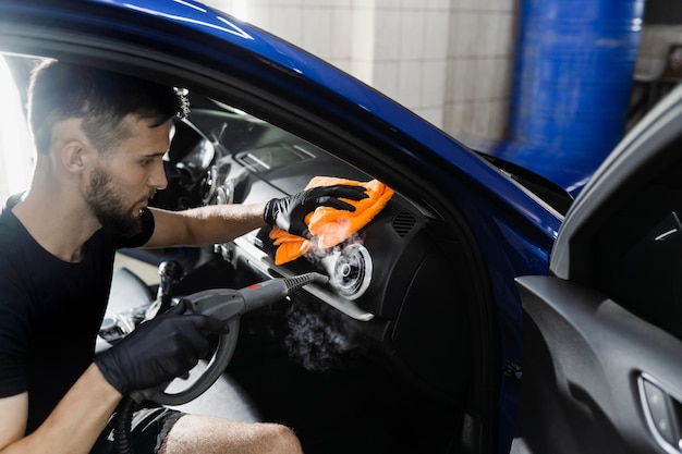 Limpeza a vapor do sistema de ar Trabalhador no serviço de limpeza automática carro limpo dentro do interior do carro