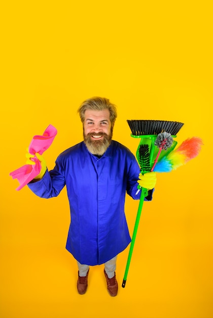 Limpeza da casa hora da limpeza homem sorridente de uniforme com equipamento de limpeza serviço doméstico