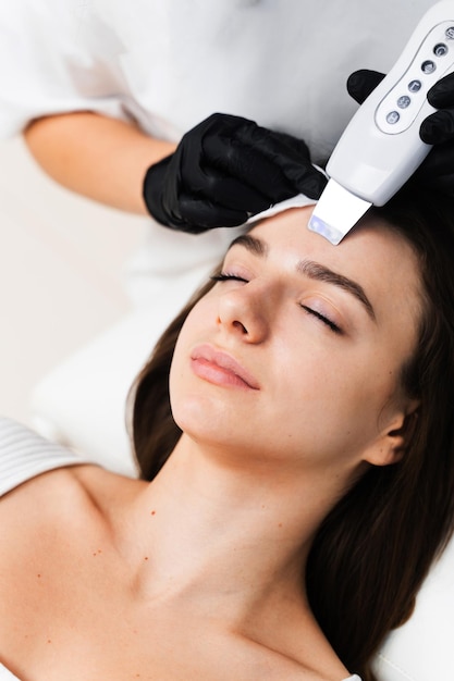 Limpeza da pele facial com a ajuda de um dispositivo de cosmetologia por ultrassom Processo de aplicação de hardware de peeling por cavitação