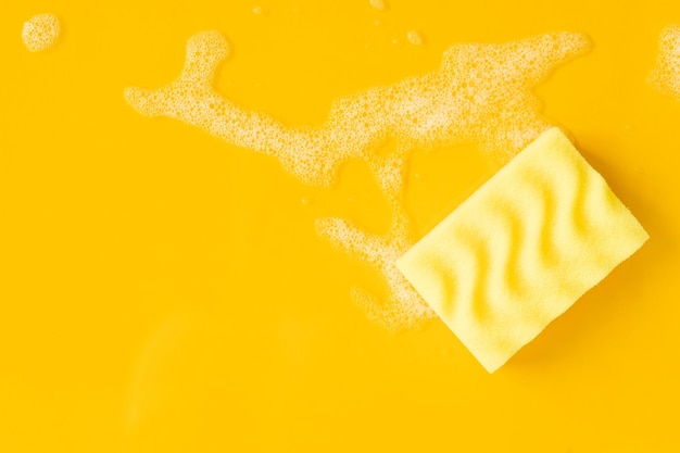 Limpeza de esponja amarela e uma espuma ensaboada em um fundo Serviço de limpeza do conceito de limpeza Banner