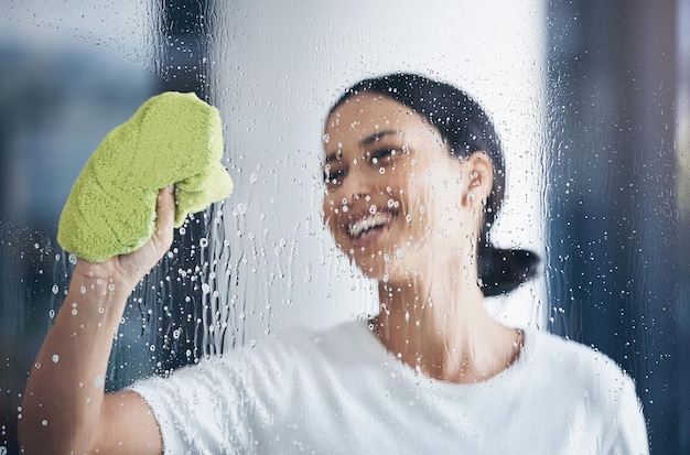 Limpeza de janela de lavagem e mulher com pano na mão para limpar detergente de água e produtos de limpeza Limpeza de higiene e garota feliz fazendo tarefas domésticas e lavar ou limpar vidro transparente