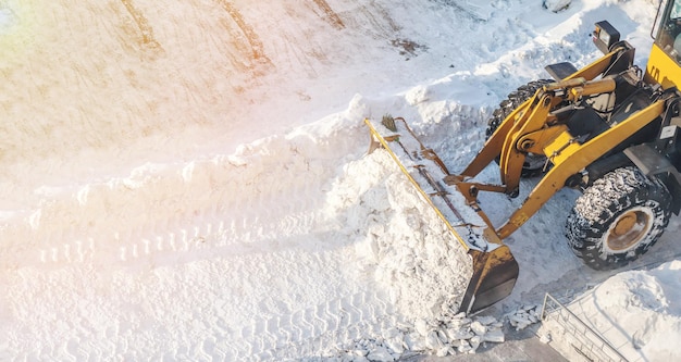 Limpeza de neve. Trator abre caminho após forte nevasca. Um grande trator laranja remove a neve
