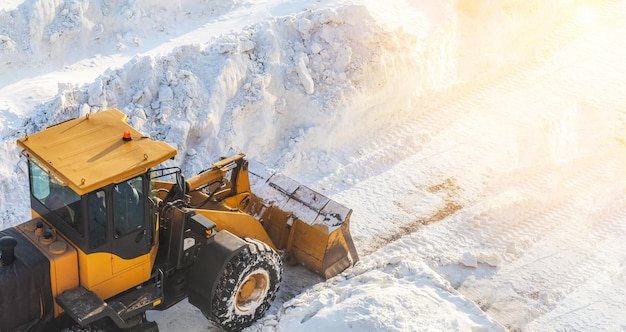 Limpeza de neve. Trator abre caminho após forte nevasca. Um grande trator laranja remove a neve