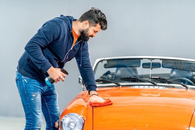 Limpeza e tratamento manual da carroceria de um conversível histórico esportivo