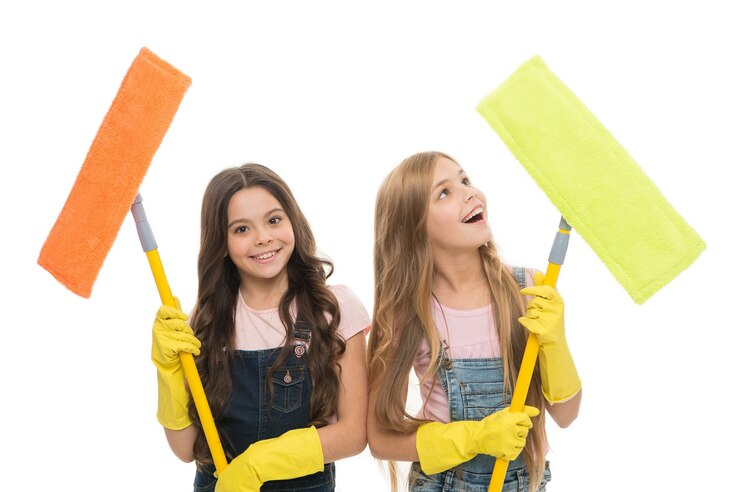Foto limpeza geral. senhoras de limpeza pequenas alegres. garotas bonitas segurando esfregões para limpar o chão. pequenos limpadores felizes sorrindo com ferramentas modernas. serviço de saneamento e limpeza.