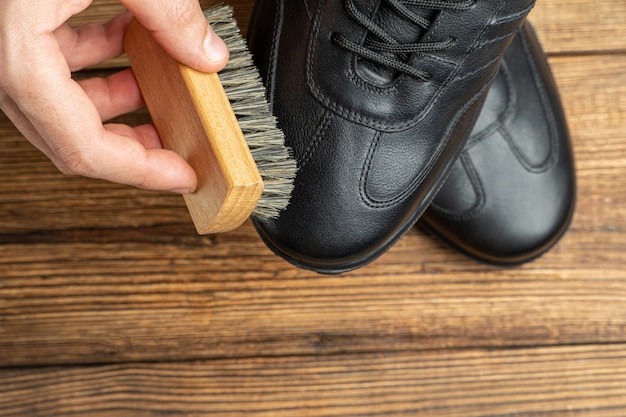 Foto limpeza polimento restauração botas de couro preto com escova